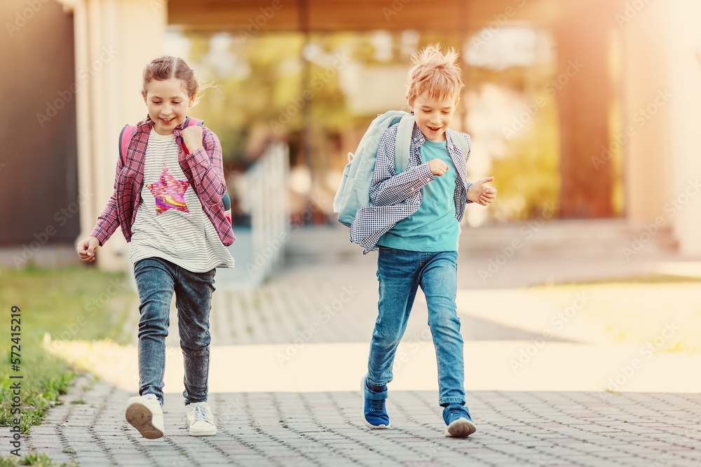 Girl and boy running from school after studying at it.