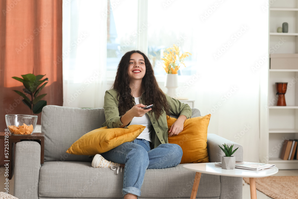 Teenage girl watching TV at home