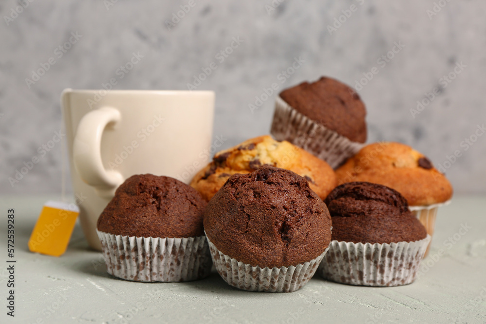 Sweet muffins and cup of tea on table