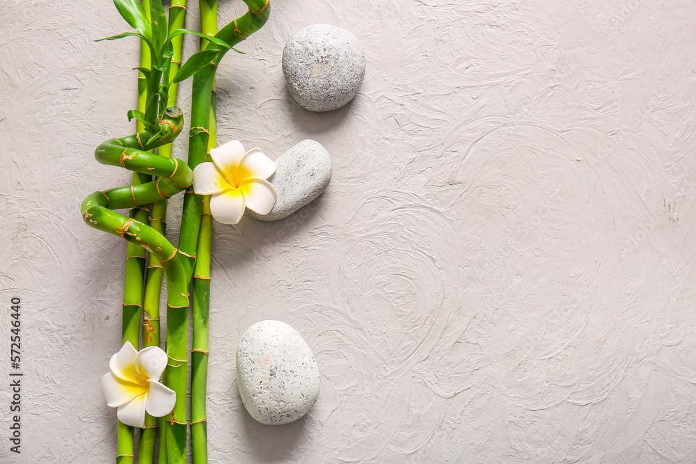 Spa stones, flowers and bamboo on light background, top view