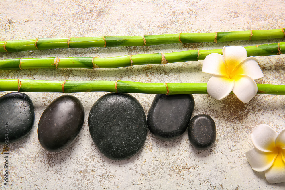 Spa stones, flowers and bamboo on light background, top view