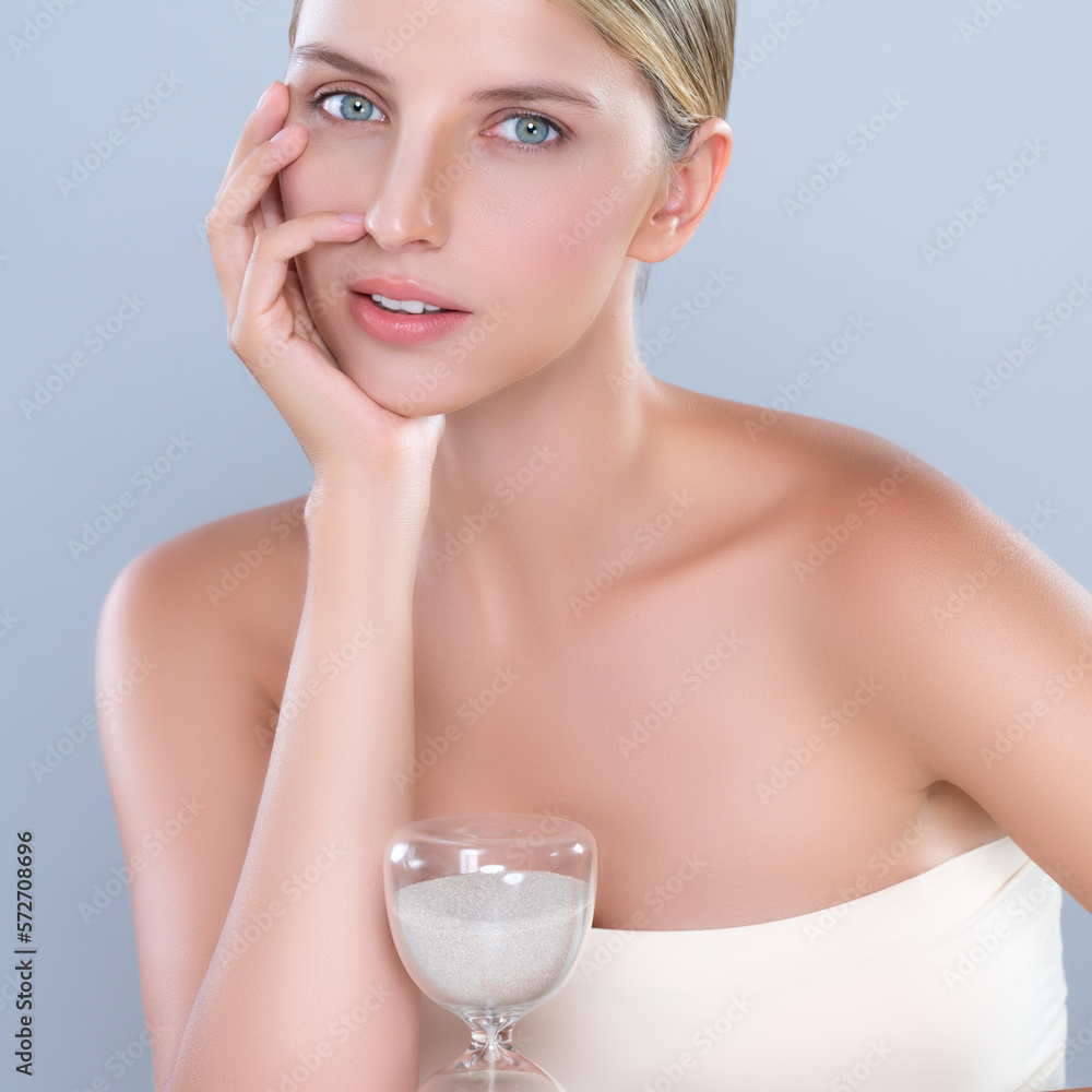 Alluring beauty model using hourglass in beauty concept of anti-aging skincare treatment for woman. 