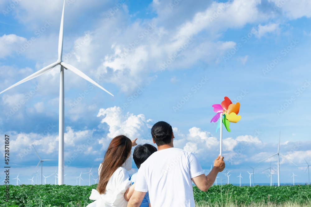 Concept of progressive happy family enjoying their time at the wind turbine farm. Electric generator