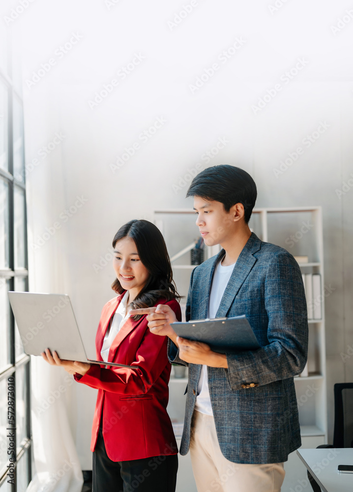 Female discussing new project with male colleague. Mature woman talking with young man in office.