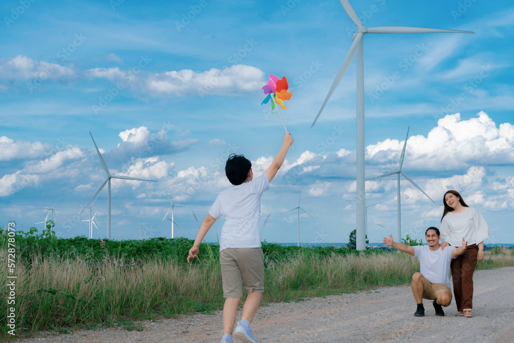 Progressive happy family enjoying their time at wind farm for green energy production concept. Wind 