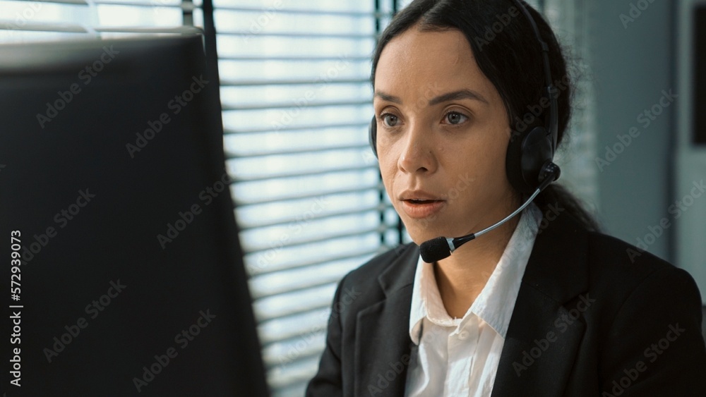 Competent female operator working on computer and talking with clients. Concept relevant to both cal