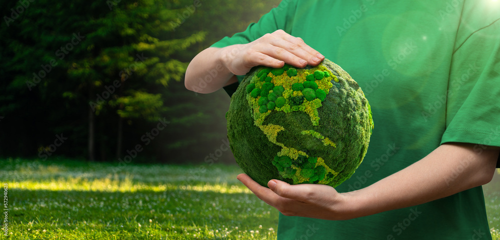 Woman holds a green planet Earth. Symbol of sustainable development and renewable energy	