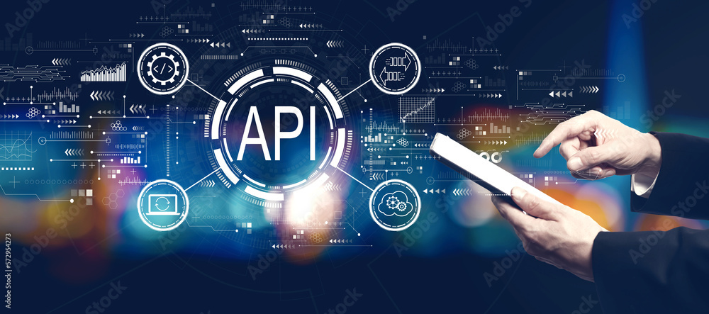 API - application programming interface concept with businessman using a tablet computer at night