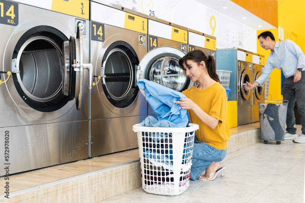 Asian people using qualified coin operated laundry machine in the public room to wash their cloths. 