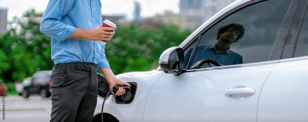 Progressive eco-friendly concept of parking EV car at public electric-powered charging station in ci