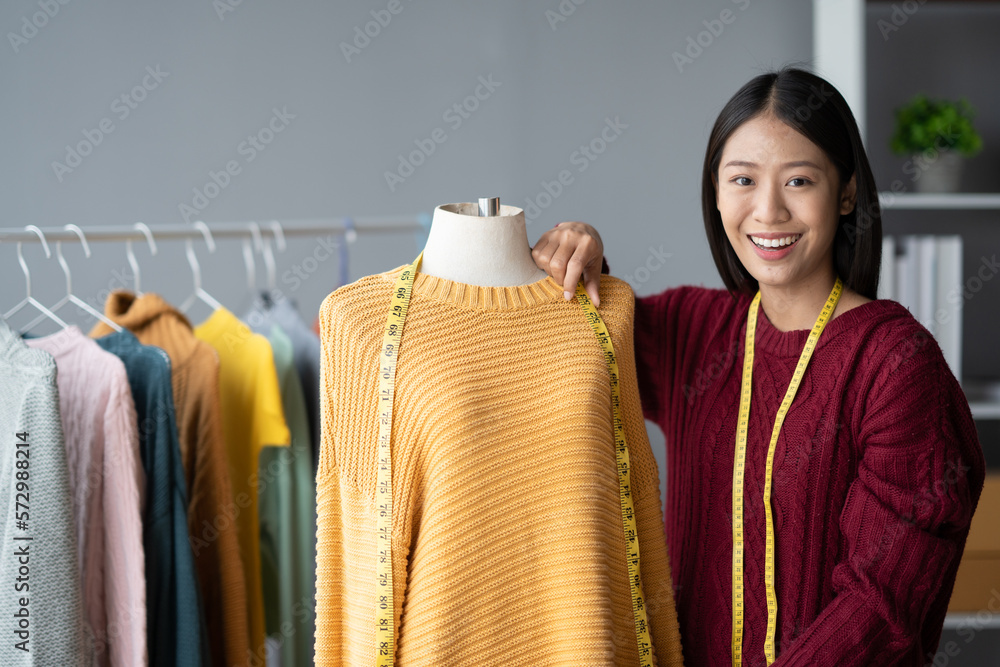 Young small cloth shop owner measuring the size for her customer with the clothes mannequin in her s