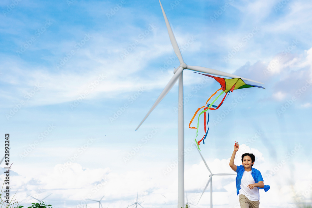 Progressive happy carefree boy concept. Young boy running along the road and flying kite at natural 