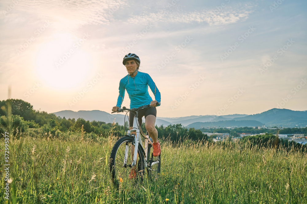 Cyclist Woman riding bike in helmets go in sports outdoors on sunny day a mountain in the forest. Si