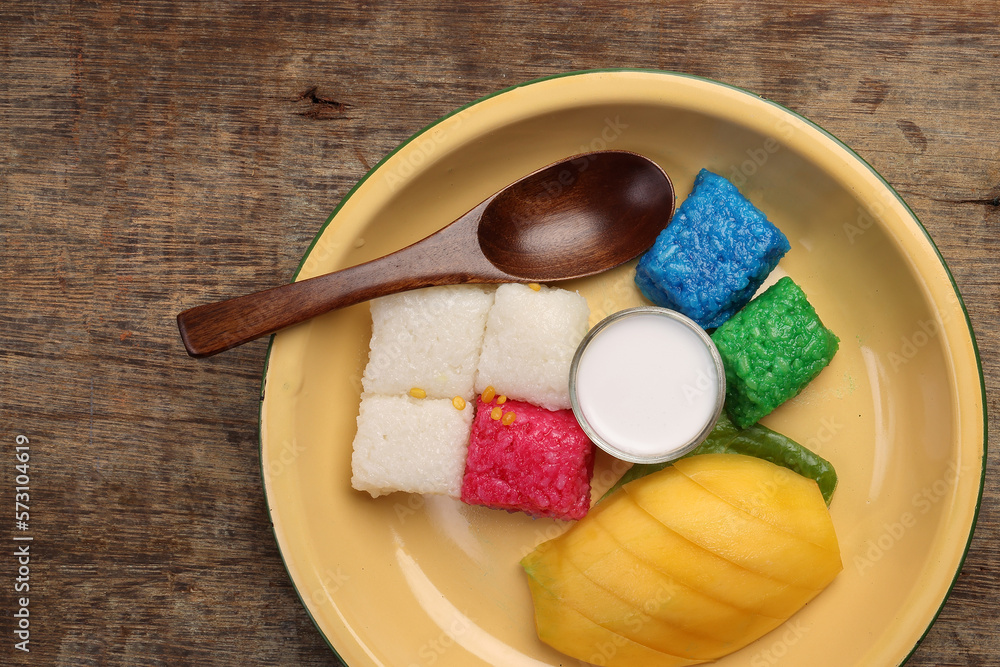 Thai sweet desert red blue yellow white mango sticky rice with coconut cream milk on enamel tin meta