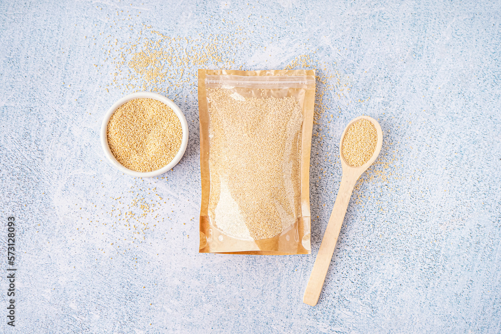 Paper bag, spoon and bowl on light background