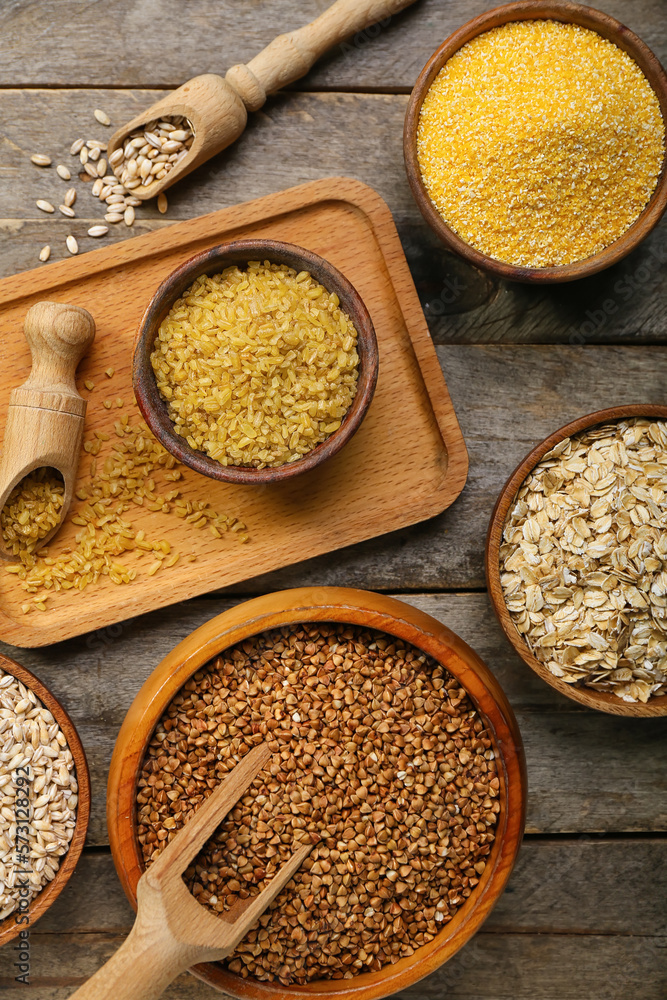 Composition with bowls of different cereals on wooden background