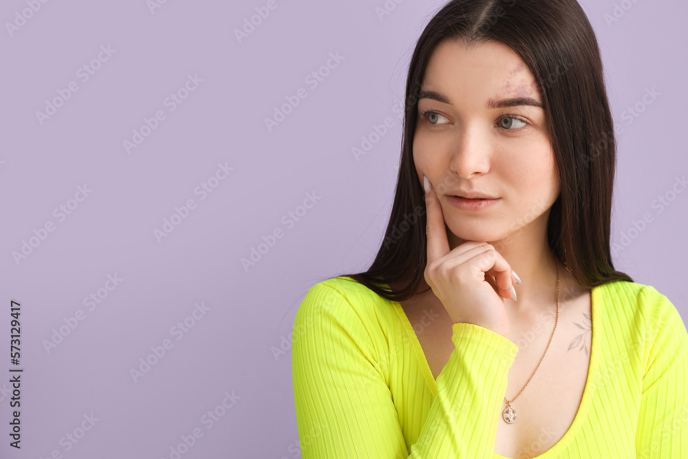 Thoughtful young woman in bright shirt on lilac background