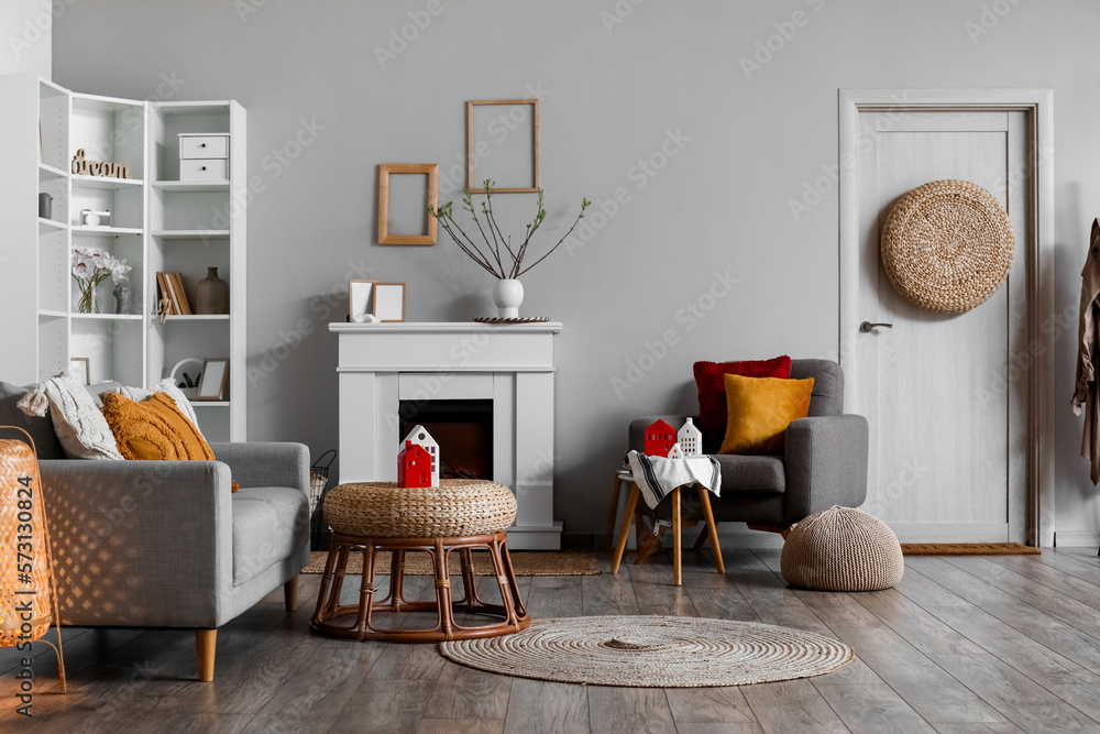 Interior of living room with fireplace, sofa and glowing candle holders