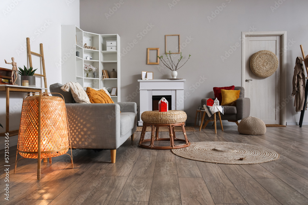 Interior of living room with fireplace, glowing lamp and candle holders