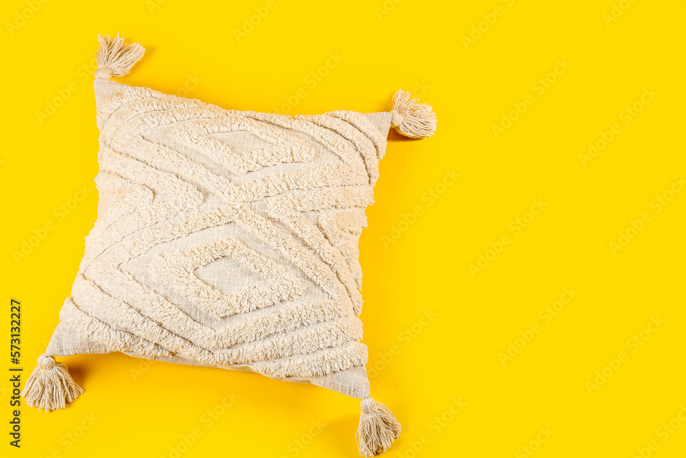 Light decorative pillow on yellow background