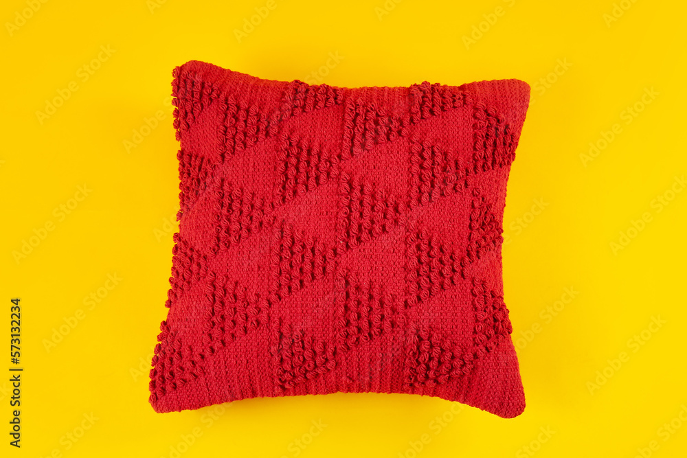 Red decorative pillow on yellow background