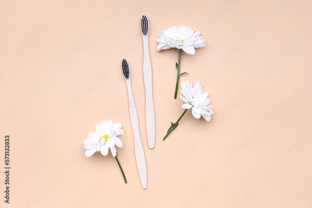 Composition with toothbrushes and chamomile flowers on color background