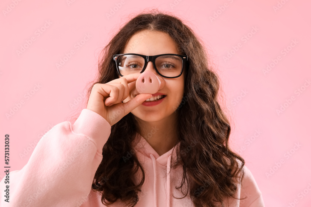 Teenage girl in funny disguise on pink background, closeup. April Fools Day celebration