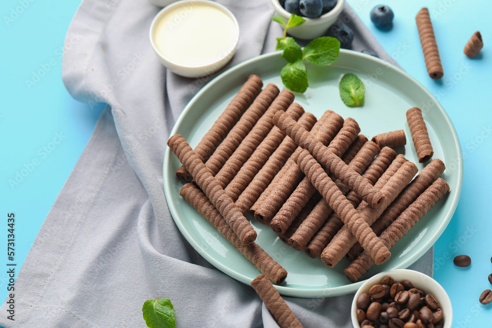 Composition with delicious chocolate wafer rolls, blueberries, coffee beans, condensed milk and mint