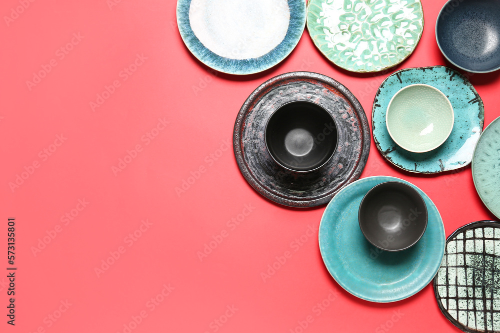 Set of stylish ceramic plates on red background