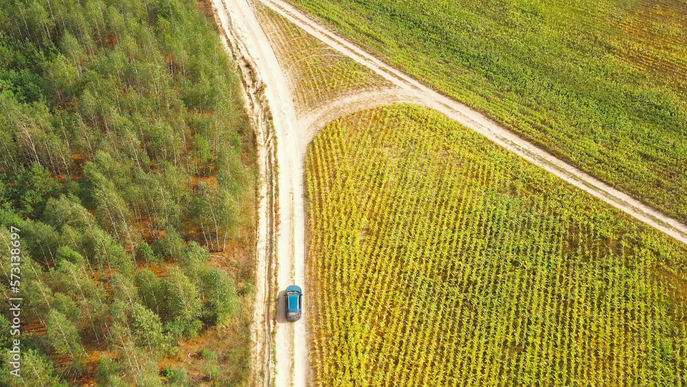 Elevated Aerial View Of Blue Car Vehicle Automobile In Fast Drive Motion On Countryside Country Road