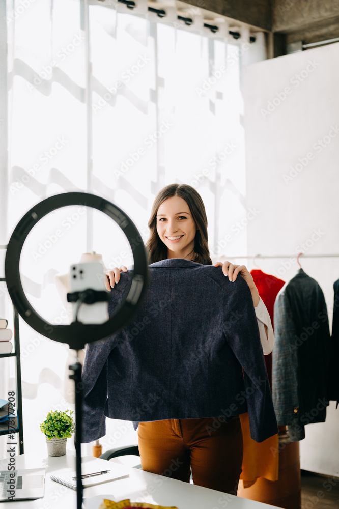 Beautiful Asian lady blogger showing clothes in front of the camera to recording vlog video live str