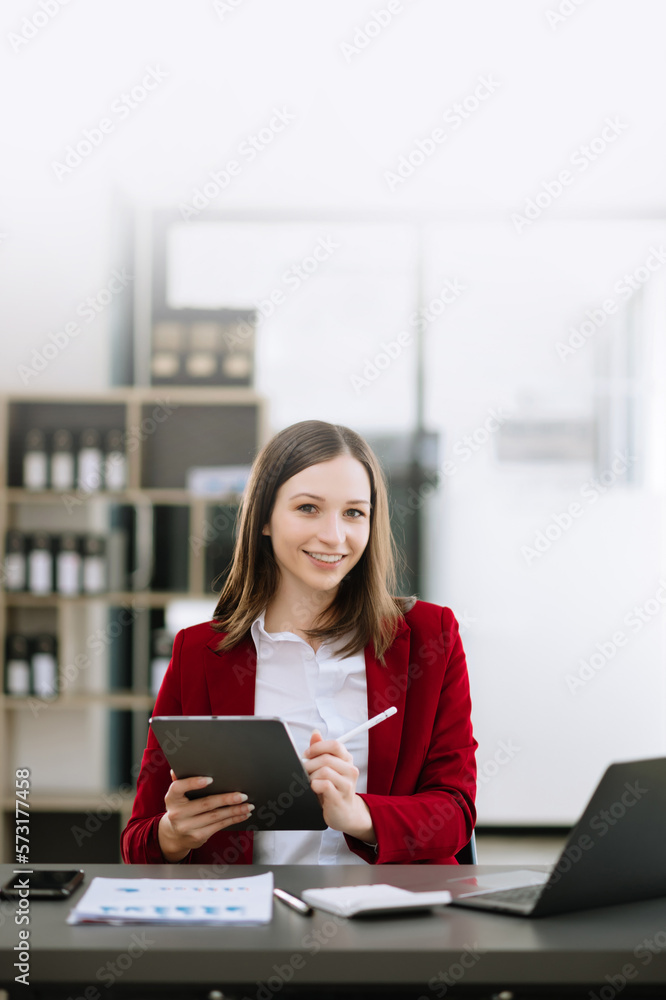 Woman freelancer is working her job on computer tablet and laptop Doing accounting analysis report r