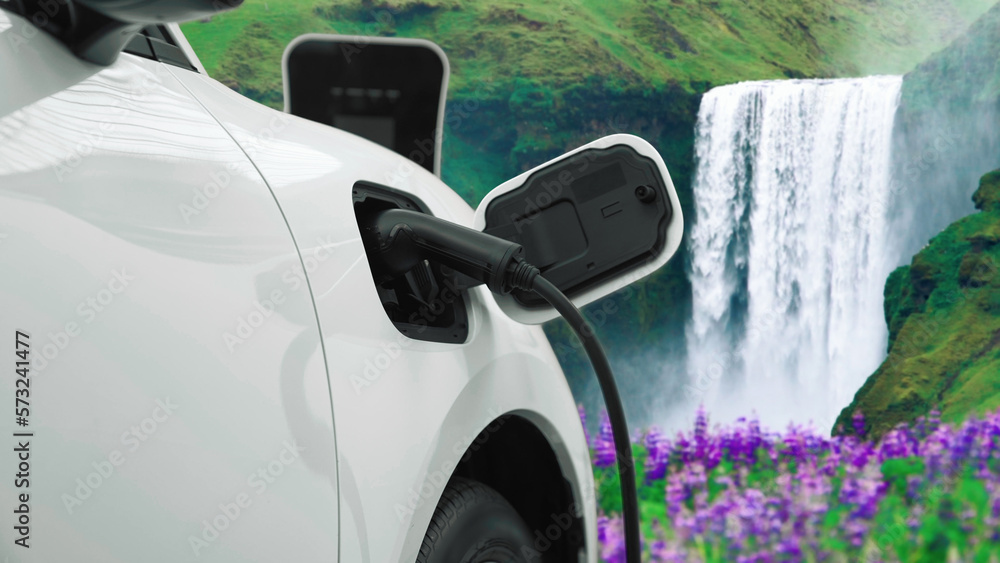 Electric car charging energy from charging station in the natural scenery, waterfall and stream back