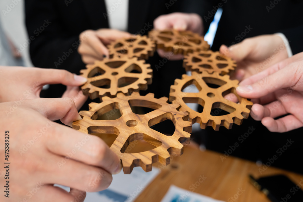 Closeup top view businesspeople hand holding gear and join together over meeting table with financia