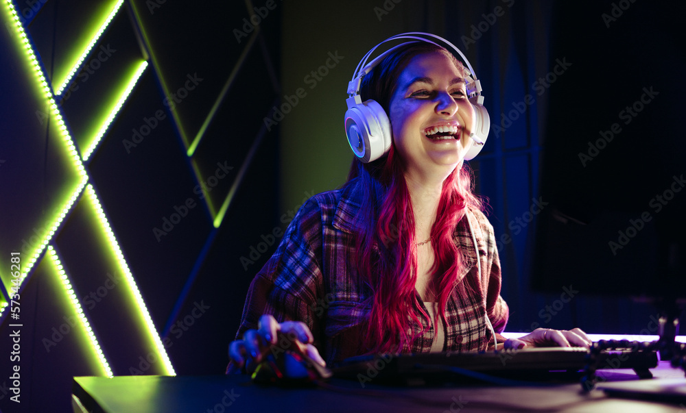 Female gamer laughing for joy, celebrating her victory in an online game