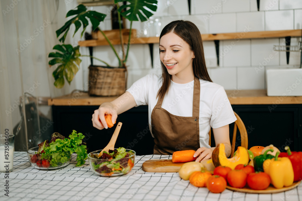 beautiful adult woman while making salad at open kitchen. healthy food concept..