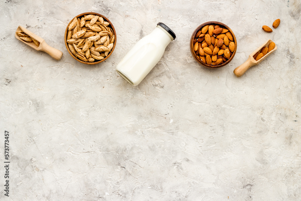 Sweet almond milk in bottle with almond seeds