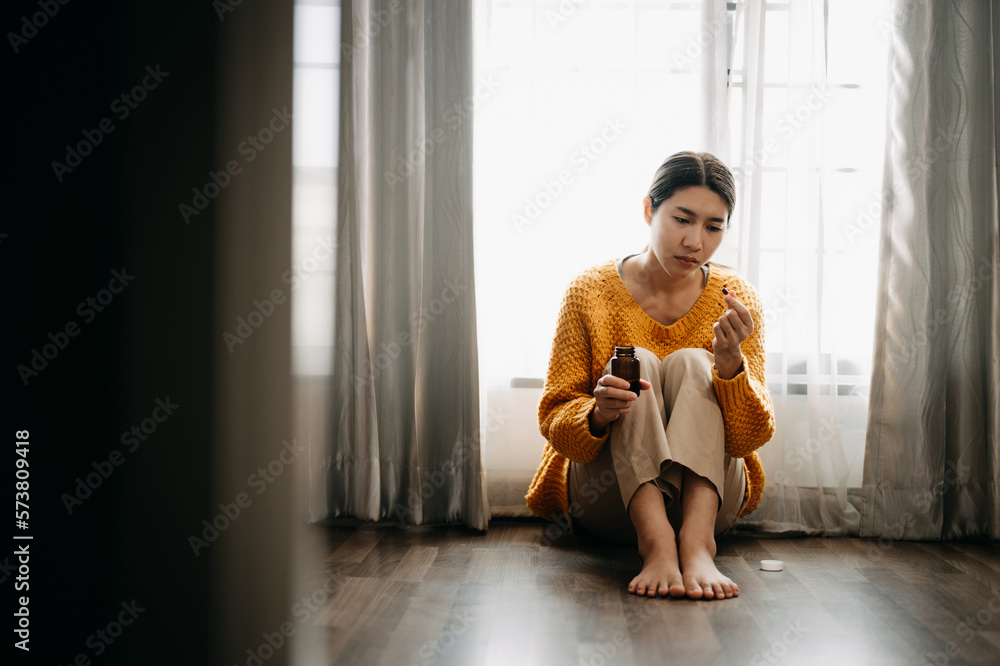  woman sit Depression Dark haired  pensive glance Standing with glass of water and pills by window a