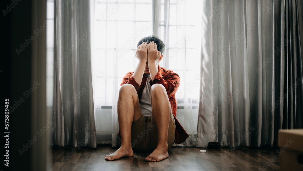 Asian Man sit Depression Dark haired  pensive glance Standing by window and anxiety Copy space.