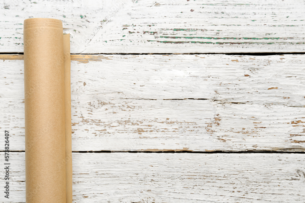 Roll of baking paper on light wooden background