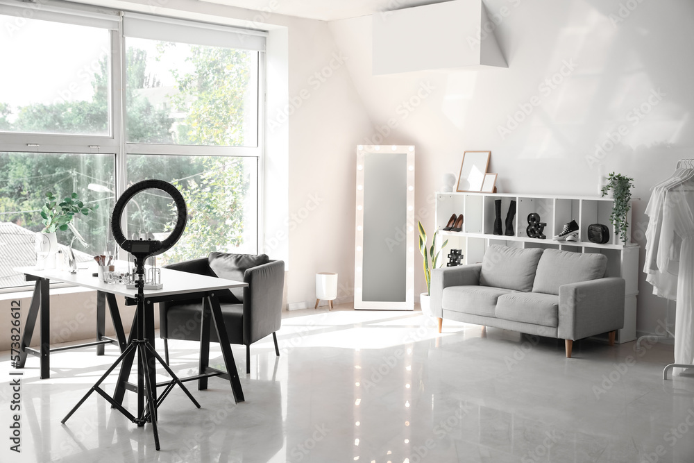 Interior of modern makeup room with table, mirror and ring light