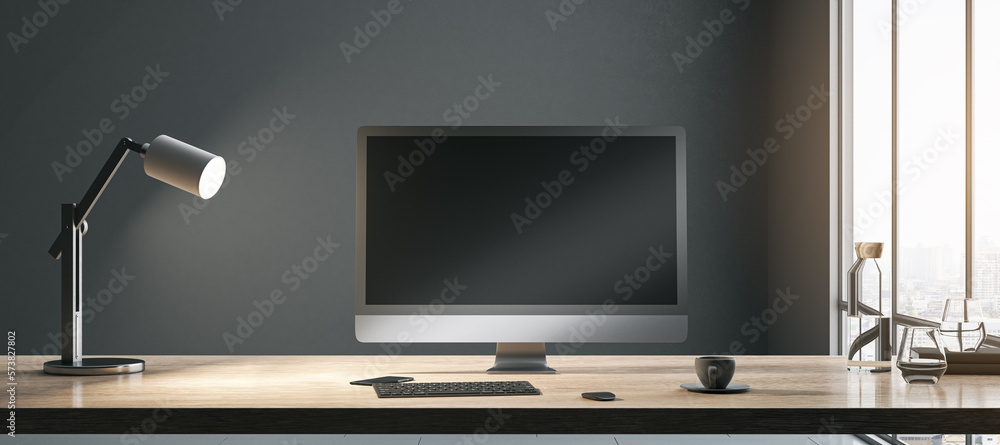 Blank black modern computer monitor with place for your web site or web design on sunlit wooden tabl