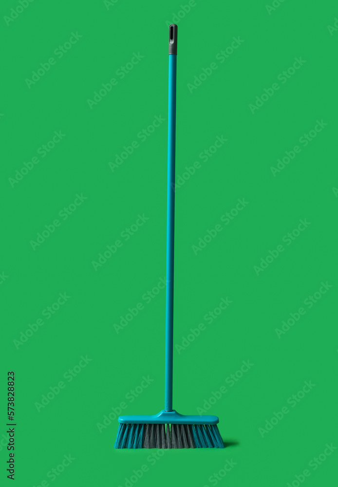 Plastic cleaning broom on green background