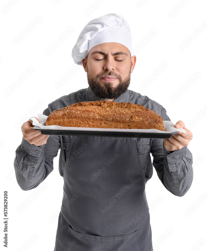 Male baker holding tray with rye bread on white background