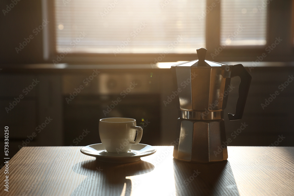 Geyser coffee maker and cup on table in kitchen