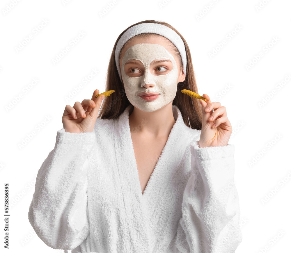 Young woman with applied turmeric mask and roots on white background