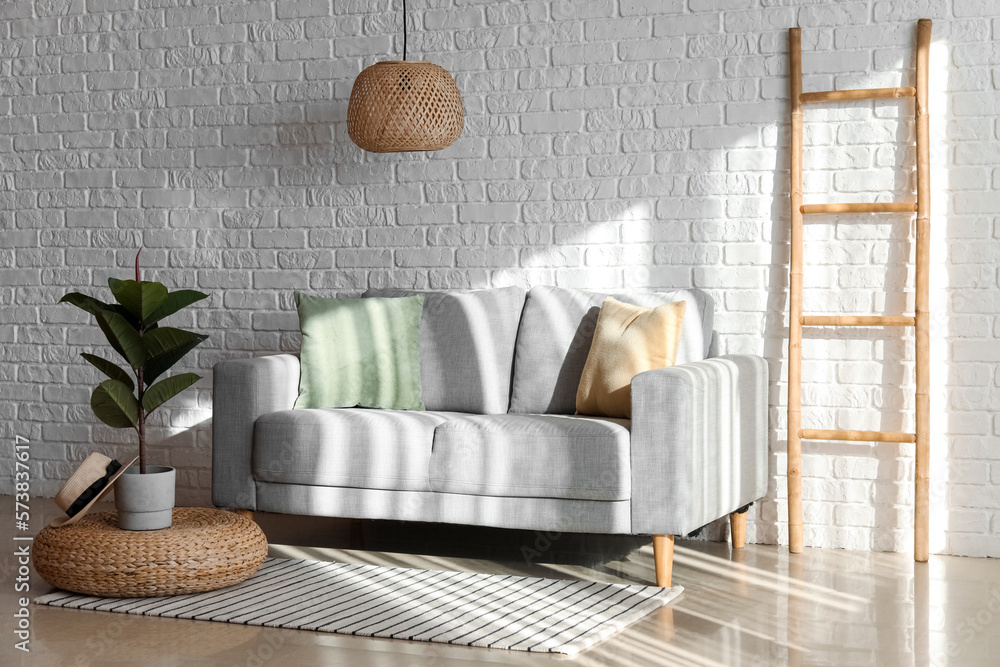 Interior of living room with grey couch and ladder