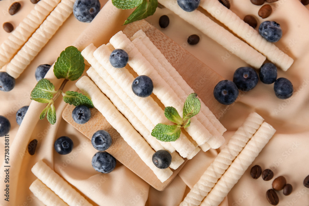 Napkin with delicious wafer rolls, blueberries, coffee beans and mint, closeup