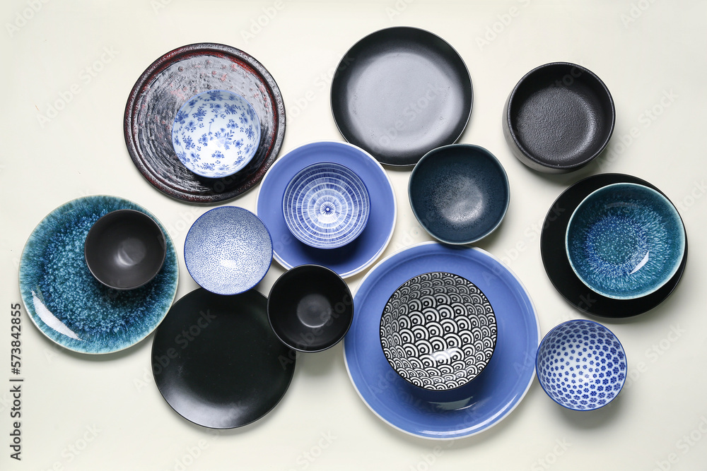 Composition with clean ceramic plates and bowls on white background