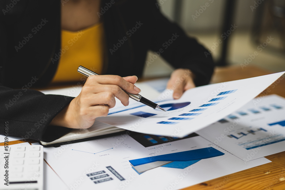 Businesswoman working with financial documents analyzing market growth report and company sales.